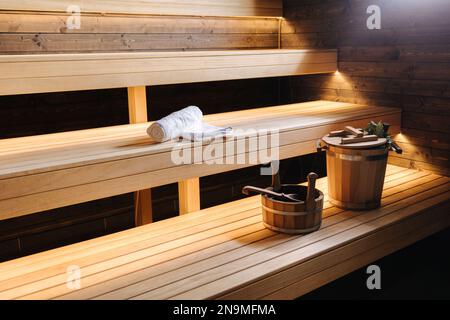 Moderne Innenausstattung der Spa-Hütte aus Holz. Blick auf den leeren finnischen Saunaraum mit Trockendampf. Neu und frisch Stockfoto