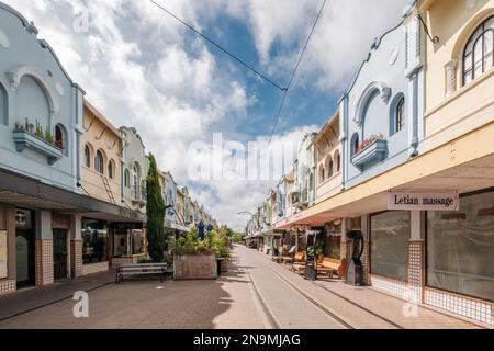 Christchurch, Neuseeland - 14. Dezember 2022: Straßenbahnlinien durch die farbenfrohen Gebäude der historischen New Regent Street im Zentrum von Chris Stockfoto