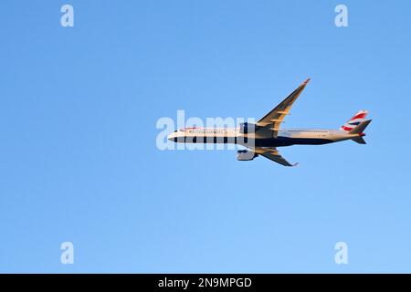 London, Vereinigtes Königreich - Februar 2023: British Airways Airbus A350 Jet (Registrierung G-XWBD) im Flug vor einem klaren blauen Himmel Stockfoto