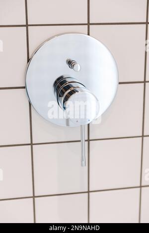 Silberner, glänzender Wasserschalter im Badezimmer Stockfoto