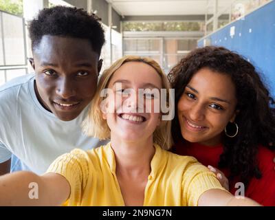 Selfie-Perspektive von drei verschiedenen Teenagern, die sich in der Highschool amüsieren Stockfoto
