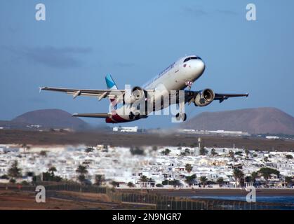 Ein Airbus A320 von Eurowings startet vom Flughafen Lanzarote Arrecife mit der Stadt hinter und unter Stockfoto