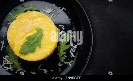 Gekochte Kartoffelpüree auf einem dunklen Teller, auf dunklem Beton Stockfoto