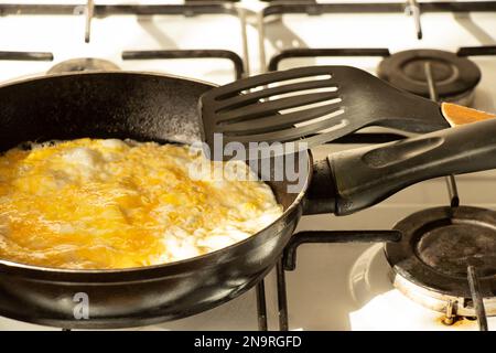 Omelette in einer Bratpfanne auf einem Gasherd zu Hause in der Küche, kochen Essen Stockfoto