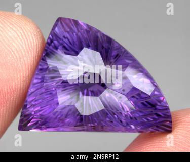 Natürlicher Edelstein, lila Amethyst auf grauem Hintergrund Stockfoto