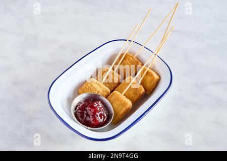 Eine Portion Mozzarella in Carrozza, gebratener Käse auf Stöcken neben einer Soße Stockfoto