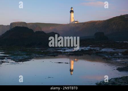 Yaquina Head Light spiegelt sich in einem Gezeitenbecken entlang der Küste Oregons bei Sonnenaufgang im Yaquina Bay State Park; Oregon, Vereinigte Staaten von Amerika Stockfoto