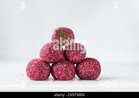 HimbeerKokosnuss und Schokoladentrüffel, hausgemachte Schokoladenbonbons auf weißem Hintergrund Stockfoto