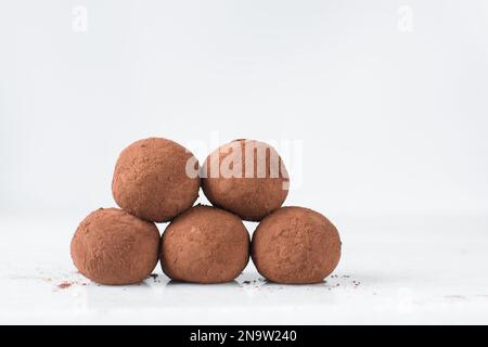 Schokoladentrüffel mit Kakaopulver, hausgemachte Schokoladenbonbons auf weißem Hintergrund Stockfoto