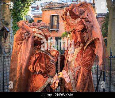 Venedig, Italien. 12. Februar 2023. Teilnehmer vor der Kirche Chiesa di San Zaccaria in aufwendigen Kostümen, oft handgefertigt und individuell gestaltet. Kostümierte Karnevalsteilnehmer und Feier mischen sich unter Touristen, Besucher und Einheimische, während der Karneval in den Straßen und Plätzen von Venedig voll im Gange ist. Kredit: Imageplotter/Alamy Live News Stockfoto