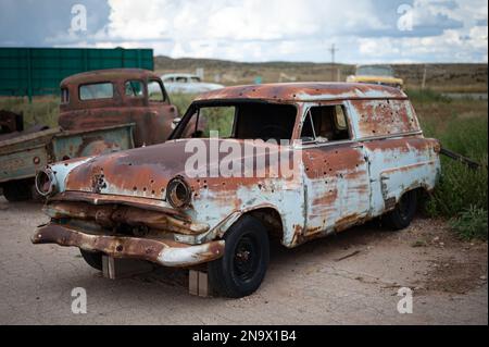 Eine alte, verlassene Ford Courier Sedan Lieferung, rostig und mit Einschusslöchern Stockfoto