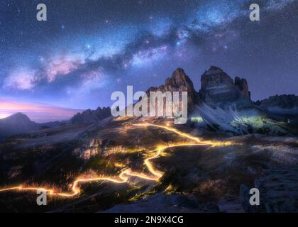 Milchstraße, Autolichtwanderungen auf der Bergstraße in Sternennacht Stockfoto