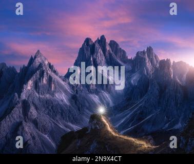 Taschenlampe Wanderwege auf Bergpfad gegen hohe Felsen in der Nacht Stockfoto