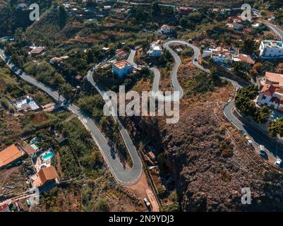 Luftaufnahme der kurvenreichen Bergstraße. Radfahrer, die mitfahren, sich sportlich betätigen. Stockfoto