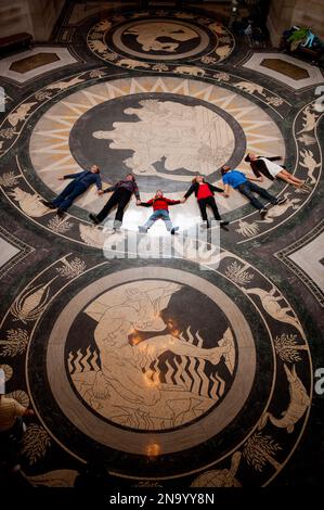 Die Tourgruppe liegt in einer Reihe auf dem dekorativen Boden der Rotunde im Nebraska State Capitol und blickt nach oben, um die Decke zu bewundern Stockfoto