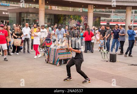 Toronto, Kanada - 07 01 2022: Straßenmusiker, der im warmen Sommer auf dem Yonge-Dundas-Platz im Zentrum Torontos Pan Flöte in einem Zuschauerkreis spielt Stockfoto