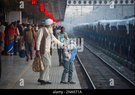 Ein älterer Mann, der ein Kind von den Bahngleisen in Chandigarh, Indien, zurückhält; Chandigarh, Neu-Delhi, Indien Stockfoto