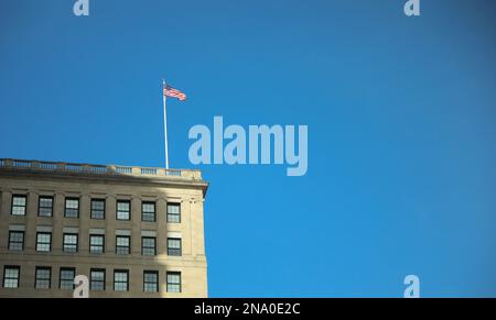 US-Flagge, die im Wind in der Stadt weht Stockfoto
