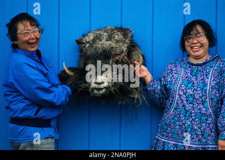 Mutter und Tochter zeigen den Kopf eines kürzlich getöteten Moschusochs auf Nunivak Island, Yukon Delta National Wildlife Refuge Stockfoto