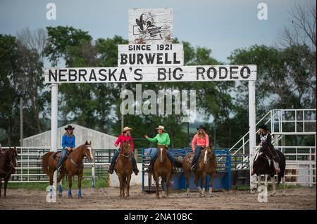 Rodeo-Königinnen auf Pferden stehen an den Rodeo-Eingangstoren; Burwell, Nebraska, Vereinigte Staaten von Amerika Stockfoto