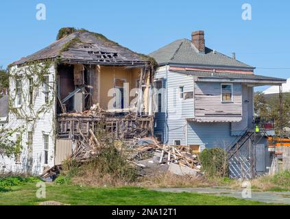 NEW ORLEANS, LA, USA - 5. FEBRUAR 2023: Rückansicht von zwei Häusern in verschiedenen Schadenszuständen im Stadtteil Central City Stockfoto