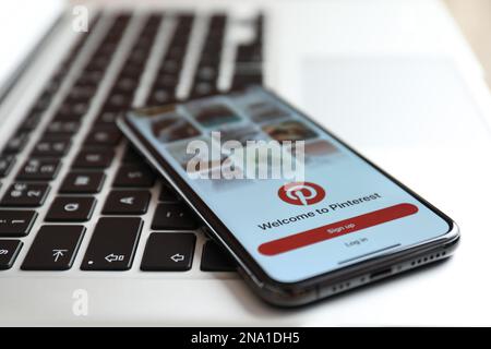 MYKOLAIV, UKRAINE - 28. AUGUST 2020: IPhone 11 zeigt Pinterest App auf MacBook Laptop an, Nahaufnahme Stockfoto