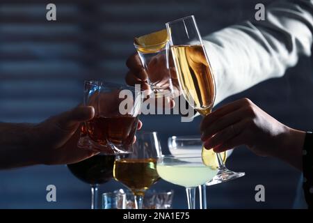 Menschen mit verschiedenen alkoholischen Getränken, die Gläser drinnen, Nahaufnahme Stockfoto