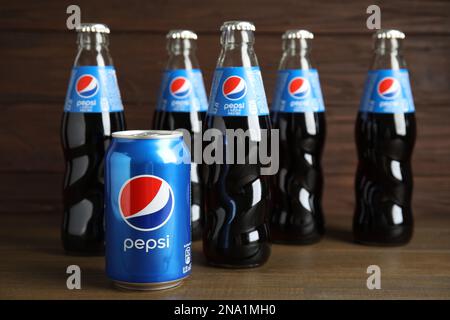 MYKOLAIV, UKRAINE - 10. FEBRUAR 2021: Flaschen und Dose Pepsi auf Holztisch Stockfoto