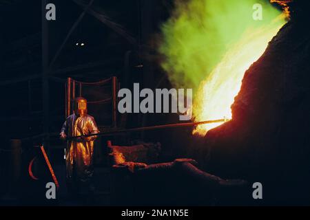 Mann in Schutzausrüstung pflegt eine Schmelzhütte bei Magma Metals Company in der Nähe von San Manuel, Arizona, USA; Vereinigte Staaten von Amerika Stockfoto