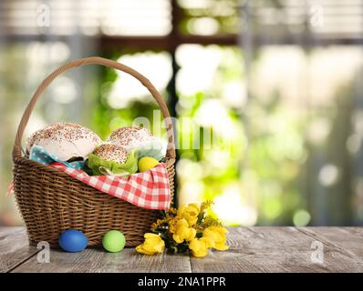 Leckere Osterkuchen und bemalte Eier auf Holztisch im Haus. Platz für Text Stockfoto