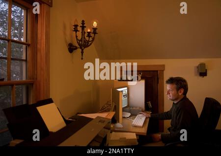 Man arbeitet an einem Computer in einem Heimbüro, Lincoln, Nebraska, USA Stockfoto