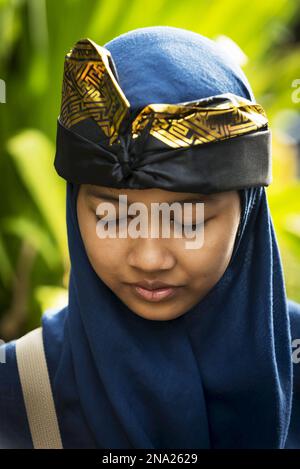 Eine junge balinesische Frau posiert bei Einer hinduistischen Zeremonie; Bali, Indonesien Stockfoto