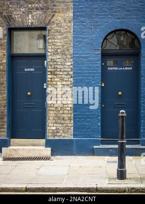 Zwei Wohntüre nebeneinander, eine mit elf Nummern und die anderen elfeinhalb, mit jeweils unterschiedlichen Fassaden und Fenstern Stockfoto