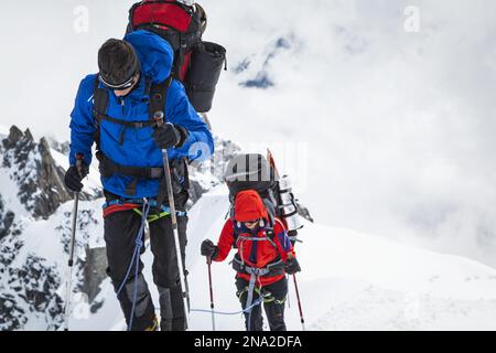 Kletterer mit Ausrüstung auf einem schneebedeckten Hügel, Aiguille du Midi, Chamonix - Mont Blanc, Alpen, Frankreich, Europa, Sommer. Stockfoto