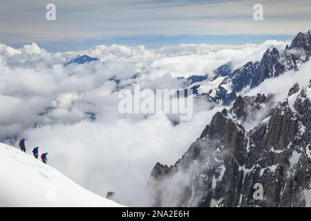 Kletterer verlassen Aiguille du Midi, umgeben von Gipfeln der französischen Alpen. Chamonix - Mont Blanc, Alpen, Frankreich, Europa, Sommer. Stockfoto