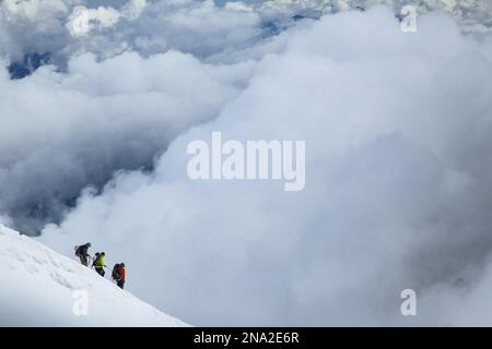 Kletterer verlassen Aiguille du Midi in die Wolken. Chamonix - Mont Blanc, Alpen, Frankreich, Europa, Sommer. Stockfoto