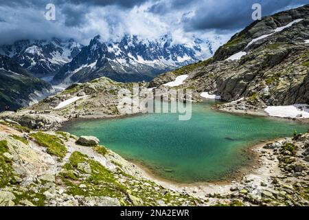 Kein Lac Blanc mit Blick auf das Mont Blanc Massiv und Mer de Glace unter dramatischen Wolken; Chamonix-Mont-Blanc, Haute-Savoie, Frankreich Stockfoto