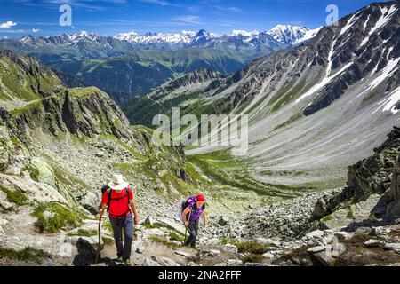 Wanderer klettern auf den „Fenetre d'Arpette“-Gebirgspass, Schweizer Alpen im Hintergrund; Trient, Martigny, Schweiz Stockfoto