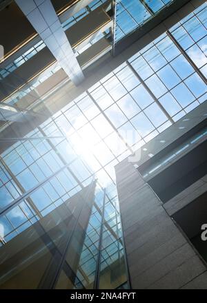 Modernes Bürogebäude, niedriger Winkel mit Blick auf den Himmel und Sonneneruptionen. Stockfoto