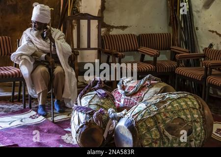 Äthiopisch-orthodoxer Priester und Gebetstrommeln in der Felsenkirche Abreha we Atsbeha, Region Tigray, Äthiopien Stockfoto