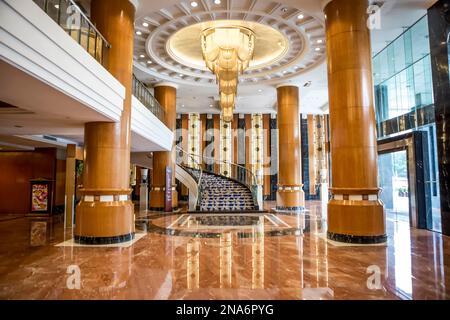 Innenausstattung einer luxuriösen Hotellobby mit Treppenaufgang, flankiert von Marmorsäulen; Guangzhou Shi, Guangdong Sheng, China Stockfoto