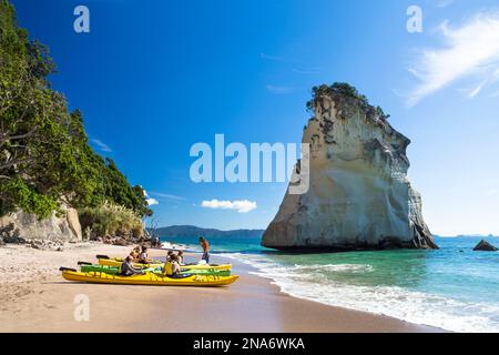 Kajakfahrer machen sich bereit, in Cathedral Cove, Coromandel Peninsula, Neuseeland, auf das Wasser zu fahren Stockfoto