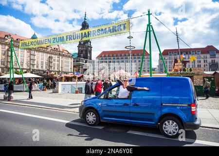 Vor dem Altmarkt hängt eine Frau mit aufgeregt gestreckten Armen aus dem Autofenster und entdeckt ein Outdoor-Festival im Dresdner... Stockfoto