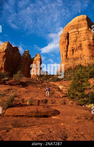 Dramatische Ansicht der roten Sandsteinformationen in Sedona mit Wanderern im Vordergrund; Sedona, Arizona, Vereinigte Staaten von Amerika Stockfoto