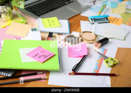 Unordentlicher Tisch mit Laptop und Kosmetik. Das Konzept, von der Arbeit überfordert zu werden Stockfoto