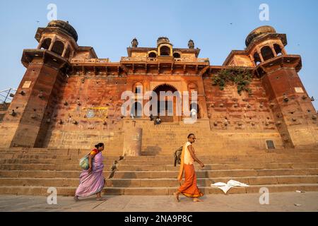 Pilger, die am Chet Singh Fort vorbeifahren, Varanasi Ghats am Ufer des Ganges, Uttar Pradesh, Indien; Varanasi, Uttar Pradesh, Indien Stockfoto