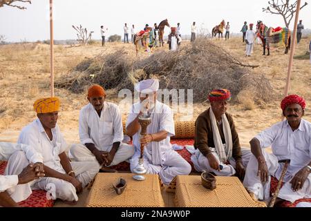 Dorflehrer rauchen Shisha in der Wüste Thar in Rajasthan, Indien; Nagaur, Rajasthan, Indien Stockfoto