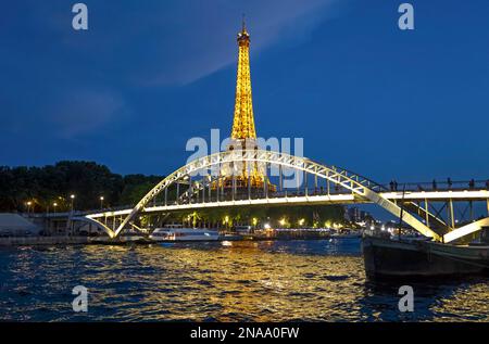 Eiffelturm und Debilly-Fußgängerbrücke bei Nacht beleuchtet in Paris; Paris, Frankreich Stockfoto