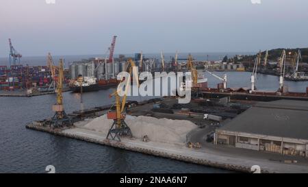 Luftaufnahme des Seehafens am Abend. Lagergebäude mit Getreide- und Turmkränen. Stockfoto