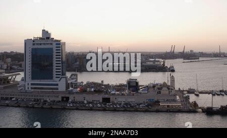 Abendliche Landschaft des Odessa Hotels am Hafen. Parkplätze und Yachtdocks. Abenddämmerung bei Sonnenuntergang. Stockfoto